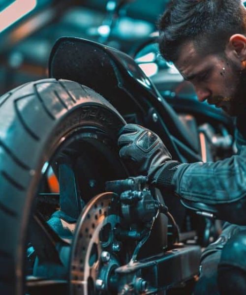 Mechanik pracujący przy tylnym kole motocykla